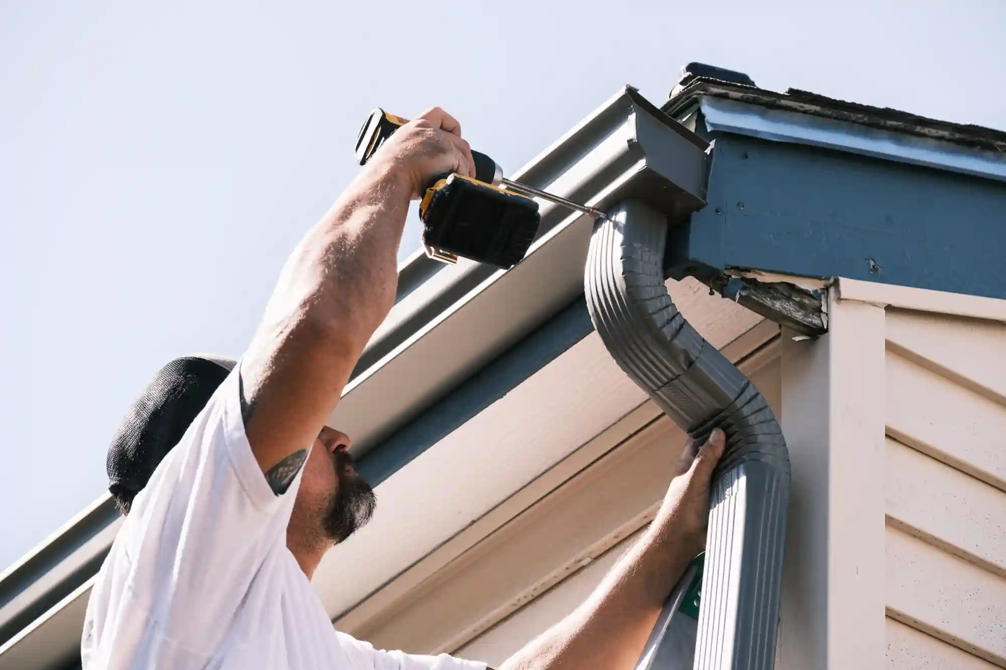 Fort Comfort crew member cutting gutter material